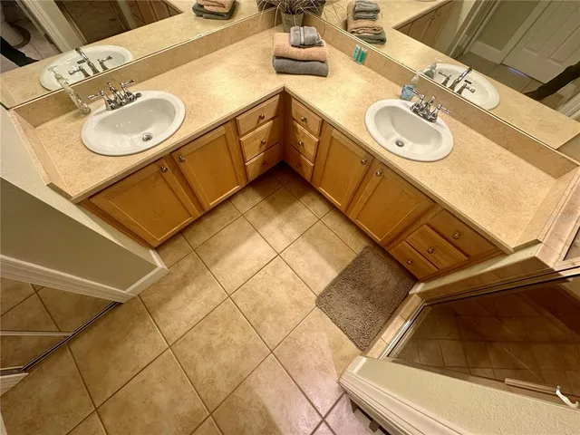 a bathroom with a granite countertop sink a toilet a mirror and shower