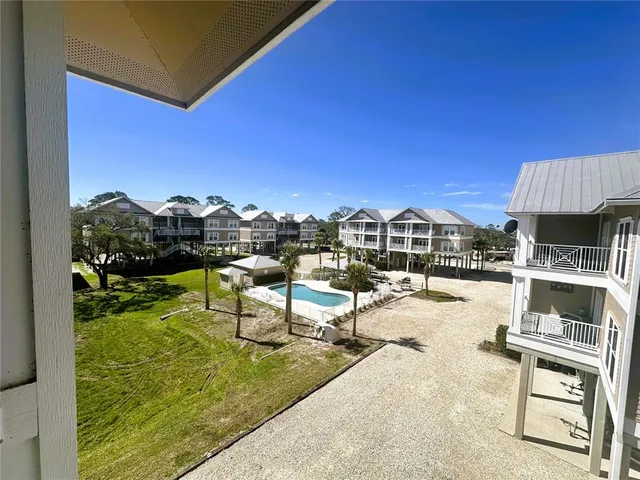 a view of a swimming pool with a patio and a yard