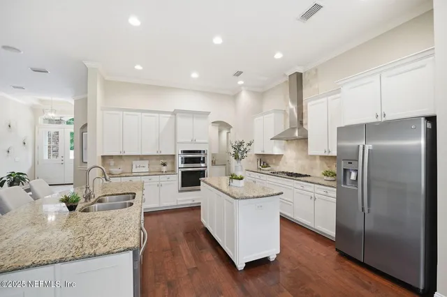 a kitchen with stainless steel appliances granite countertop a sink stove and refrigerator