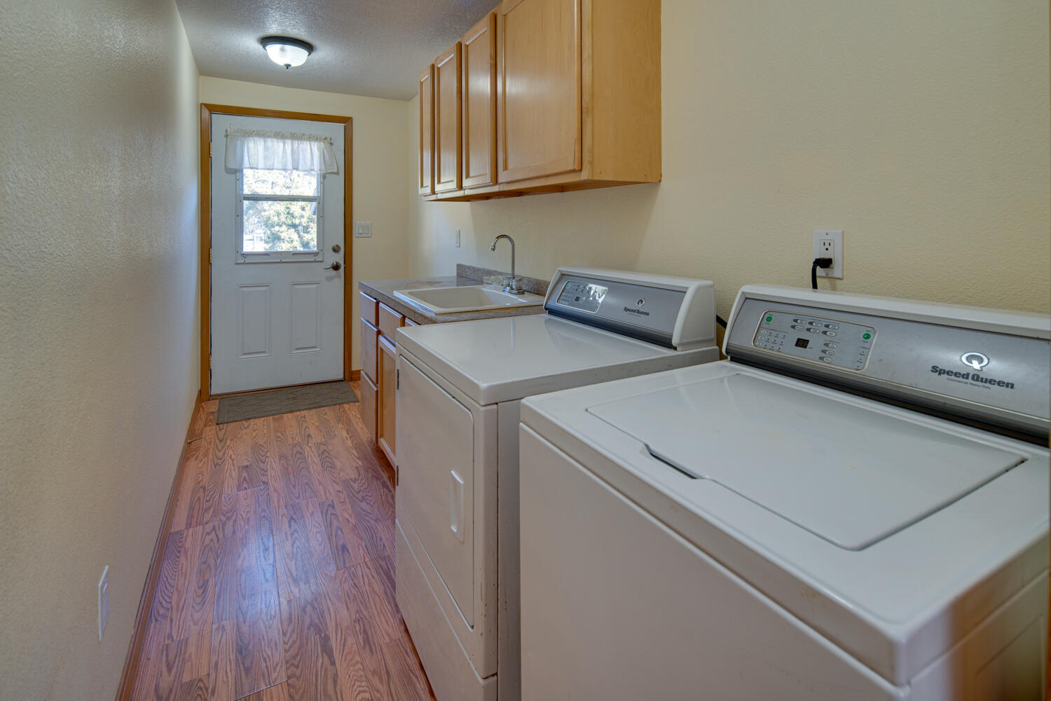 19333 Baker Road Bend, OR 97702 - Photo 12 of 49 Laundry room complete with its own access to the front deck, large utility sink with large base cabinet and upper cabinets.