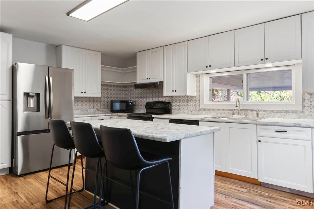 1802 Moselem Spring Road Hamburg, PA 19526 - Photo 12 of 50 a kitchen with stainless steel appliances granite countertop a refrigerator a stove a sink and white cabinets with wooden floor