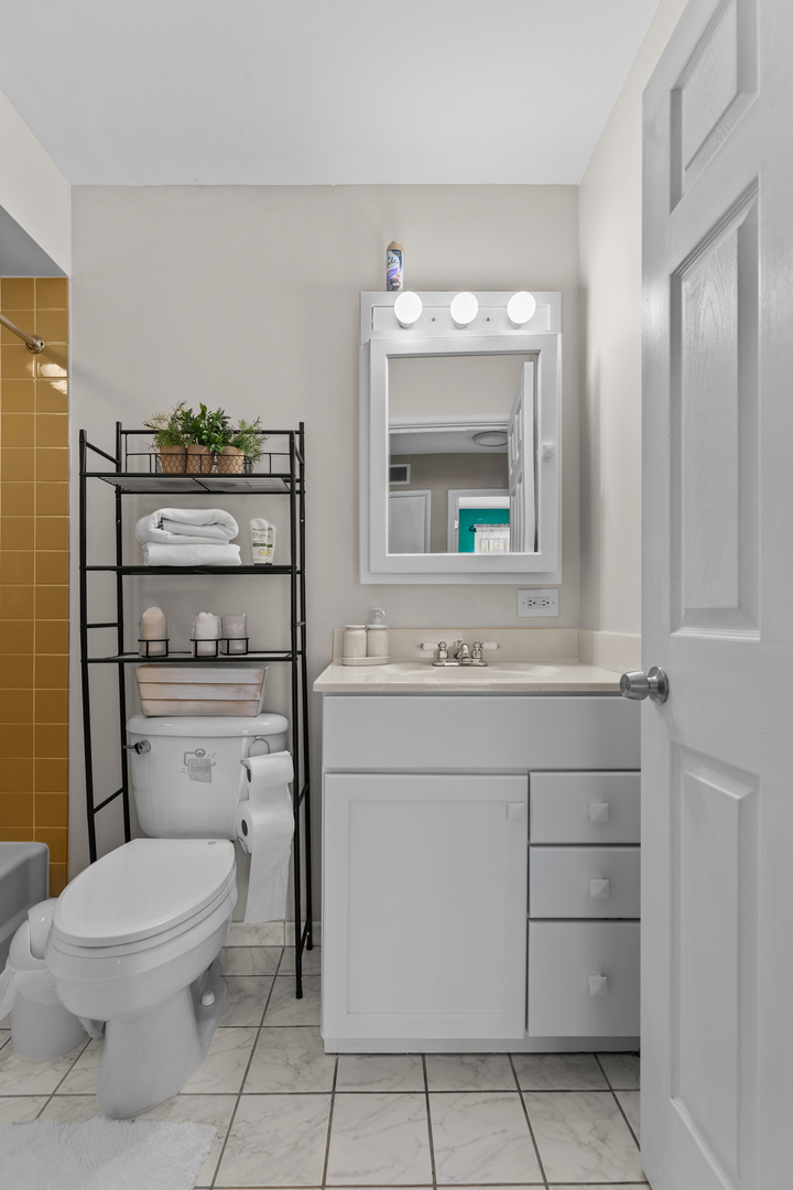 7353 Blackburn Avenue, Unit K206 Downers Grove, IL 60516 - Photo 12 of 24 a bathroom with a toilet a sink and mirror