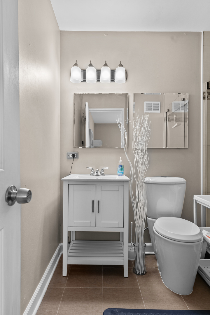 7353 Blackburn Avenue, Unit K206 Downers Grove, IL 60516 - Photo 18 of 24 a bathroom with a sink toilet and a mirror