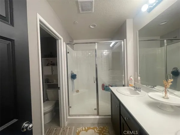a bathroom with a shower sink vanity and mirror