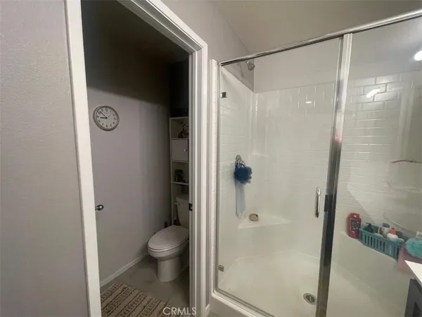 a bathroom with a granite countertop shower and a toilet