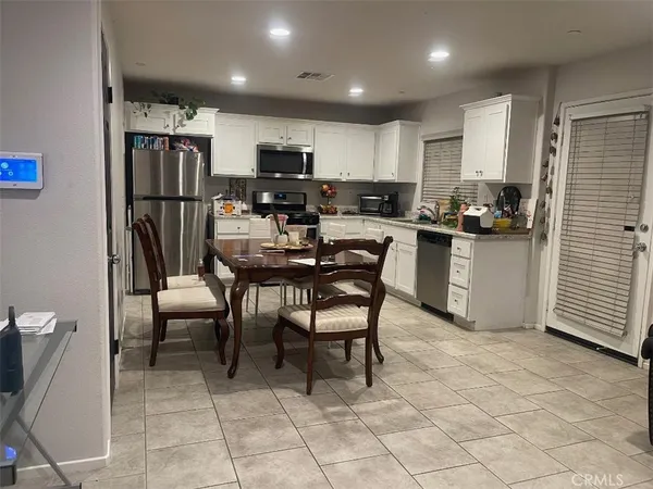 a kitchen with stainless steel appliances granite countertop a refrigerator and a stove top oven