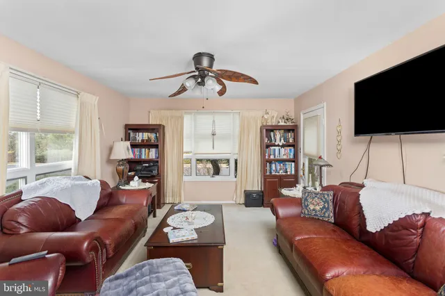 a living room with furniture ceiling fan and window