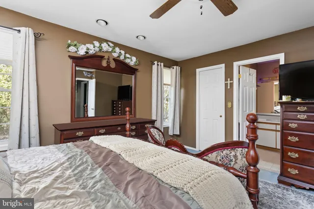 a bedroom with a bed and a large mirror on the dresser