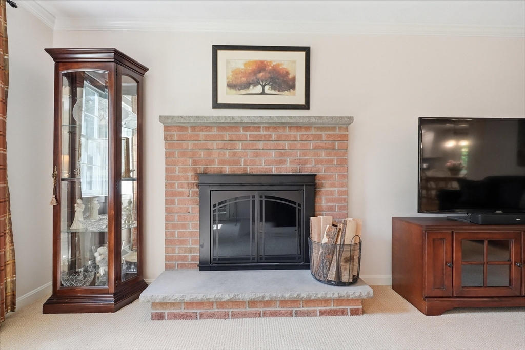 9 Fazio Farm Road Georgetown, MA 01833 - Photo 21 of 42 a living room with furniture a flat screen tv and a fireplace