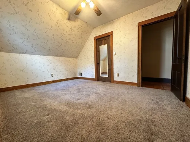 an empty room with chandelier fan