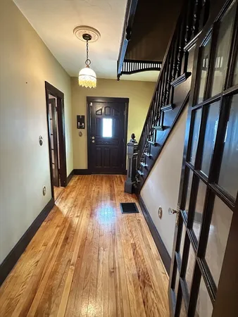 a view of entryway and hall with wooden floor