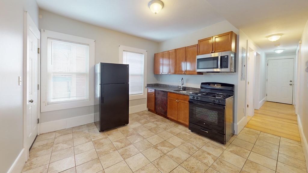 a kitchen with stainless steel appliances granite countertop a refrigerator and a stove top oven