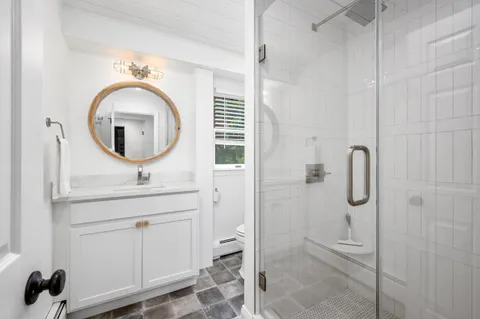 a bathroom with a sink a mirror and shower