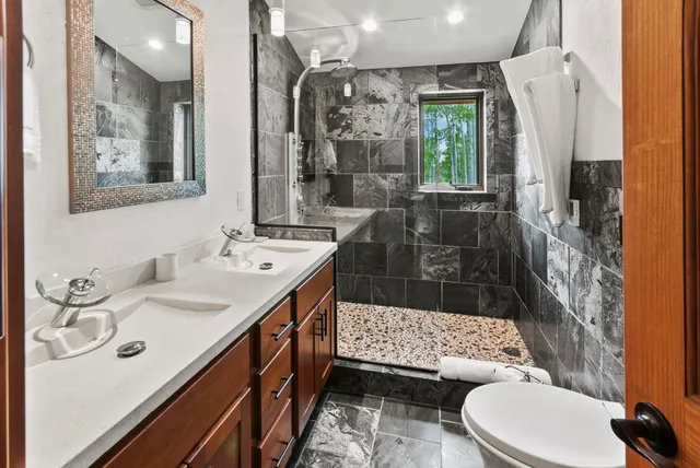 a bathroom with a sink a toilet and shower