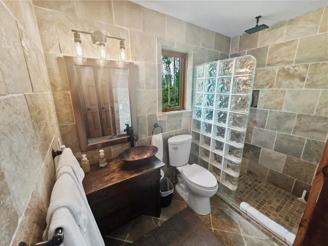 a bathroom with a granite countertop sink toilet and shower