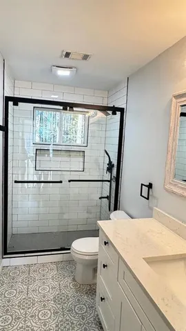 a bathroom with a sink a toilet and shower
