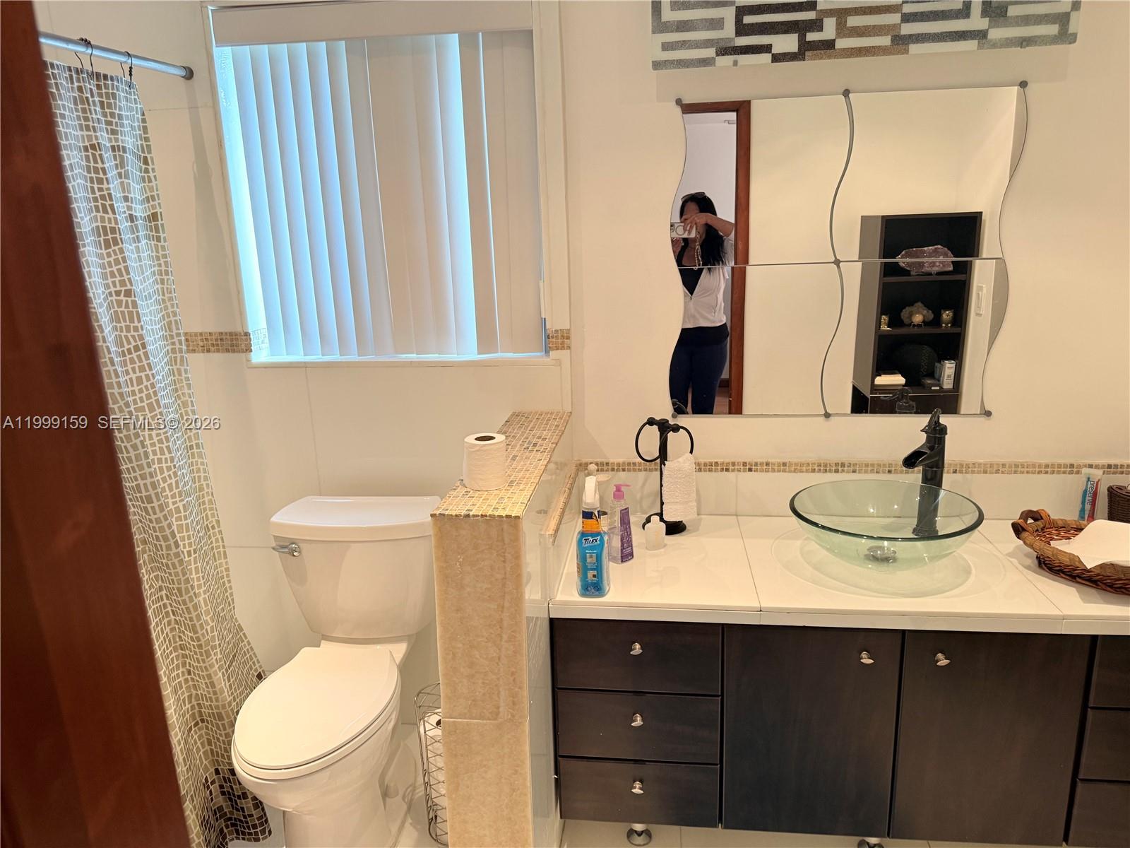 9410 Southwest 78th Street, Unit A Miami, FL 33173 - Photo 3 of 5 a bathroom with a toilet sink and mirror