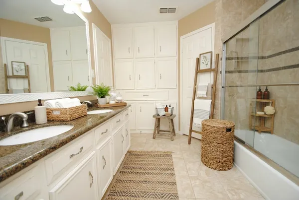 a spacious bathroom with a granite countertop sink and a mirror