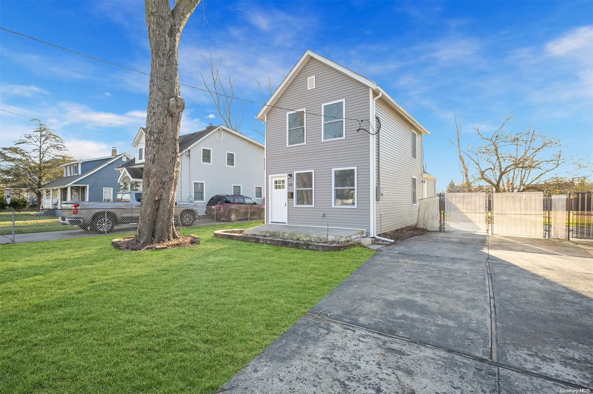 204 Oak Street Patchogue, NY 11772 - Photo 1 of 1 a front view of a house with a yard