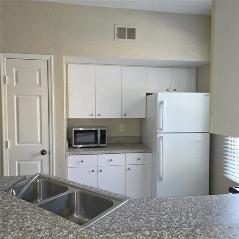a kitchen with a sink a microwave and refrigerator