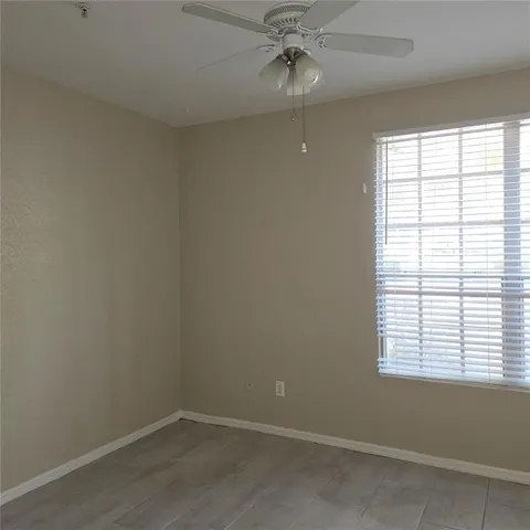 an empty room with a window and a fan