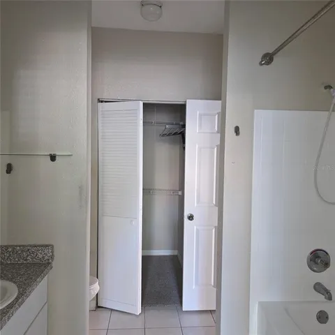 a bathroom with a granite countertop sink a mirror and a shower