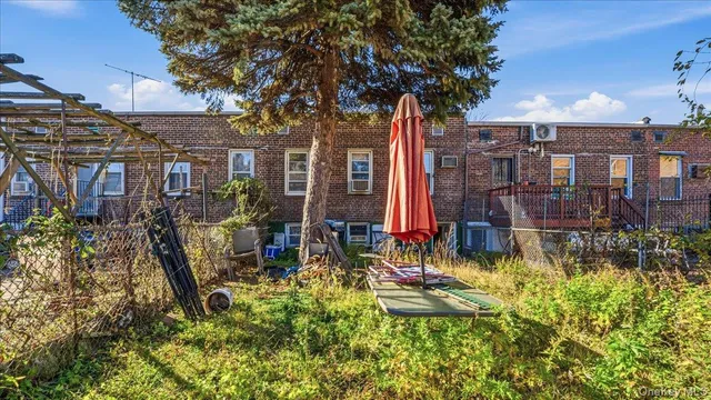 a view of house with a yard and potted plants