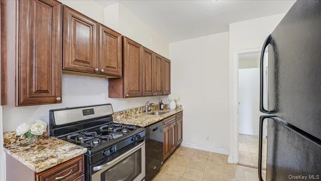 a kitchen with stainless steel appliances granite countertop a stove a sink and a refrigerator