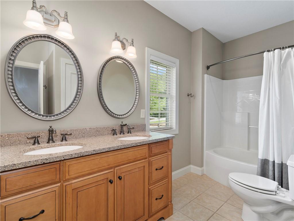 62 Vision Road Canton, NC 28716 - Photo 28 of 45 a bathroom with a granite countertop toilet a sink and a mirror