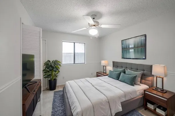 a bedroom with a bed and a potted plant
