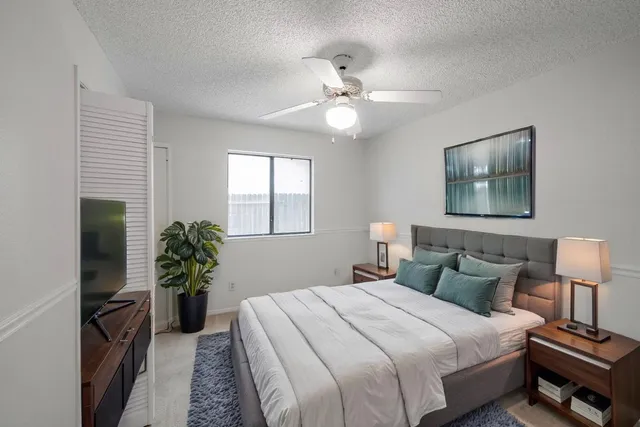 a bedroom with a bed and a potted plant