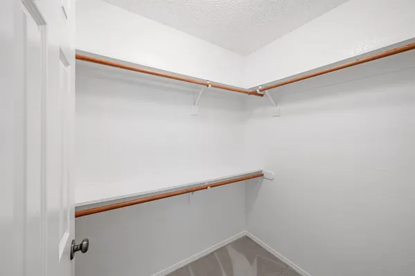 a view of walk in closet with empty racks