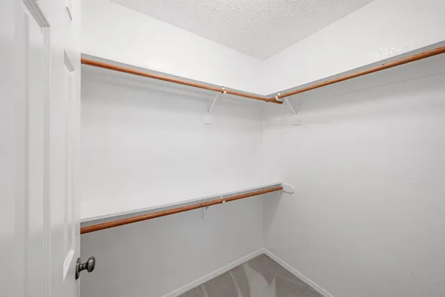 a view of walk in closet with empty racks
