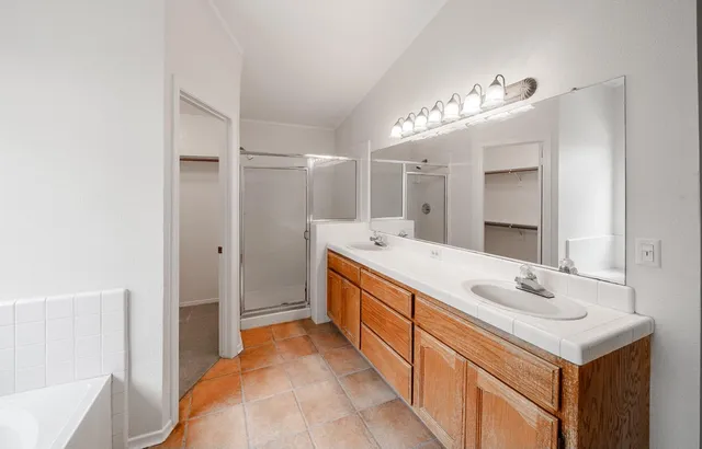 a spacious bathroom with a double vanity sink mirror and double