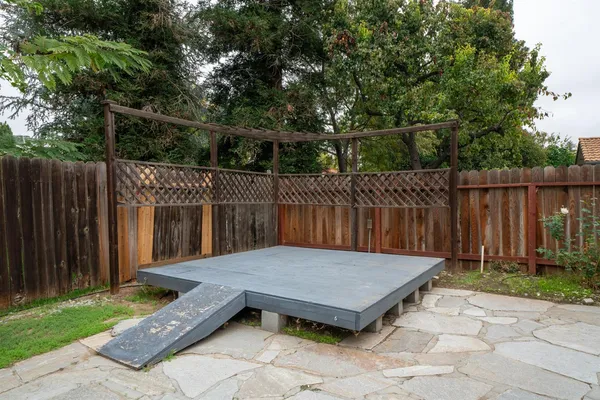 a view of backyard with small cabin and wooden fence