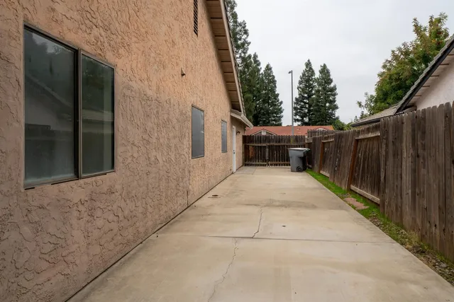 a view of a patio with table and chairs with wooden fence and plants
