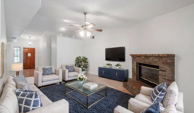 a living room with furniture a fireplace and a flat screen tv