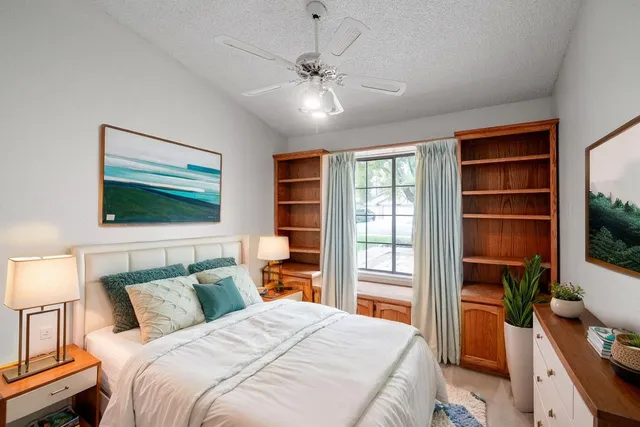 a bedroom with a large bed and a flat tv screen on dresser