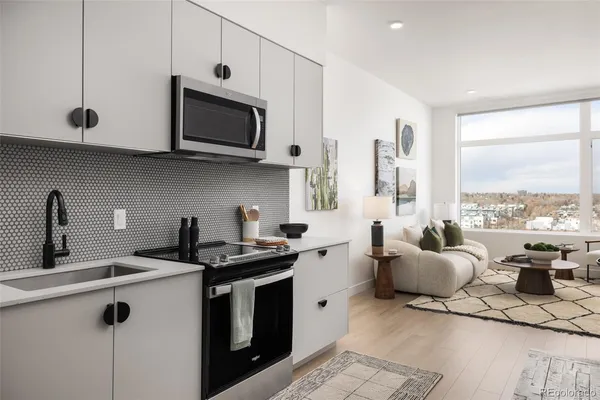 a kitchen with stainless steel appliances granite countertop a sink a stove and a microwave