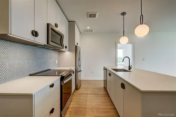 a kitchen with a sink a microwave and stove