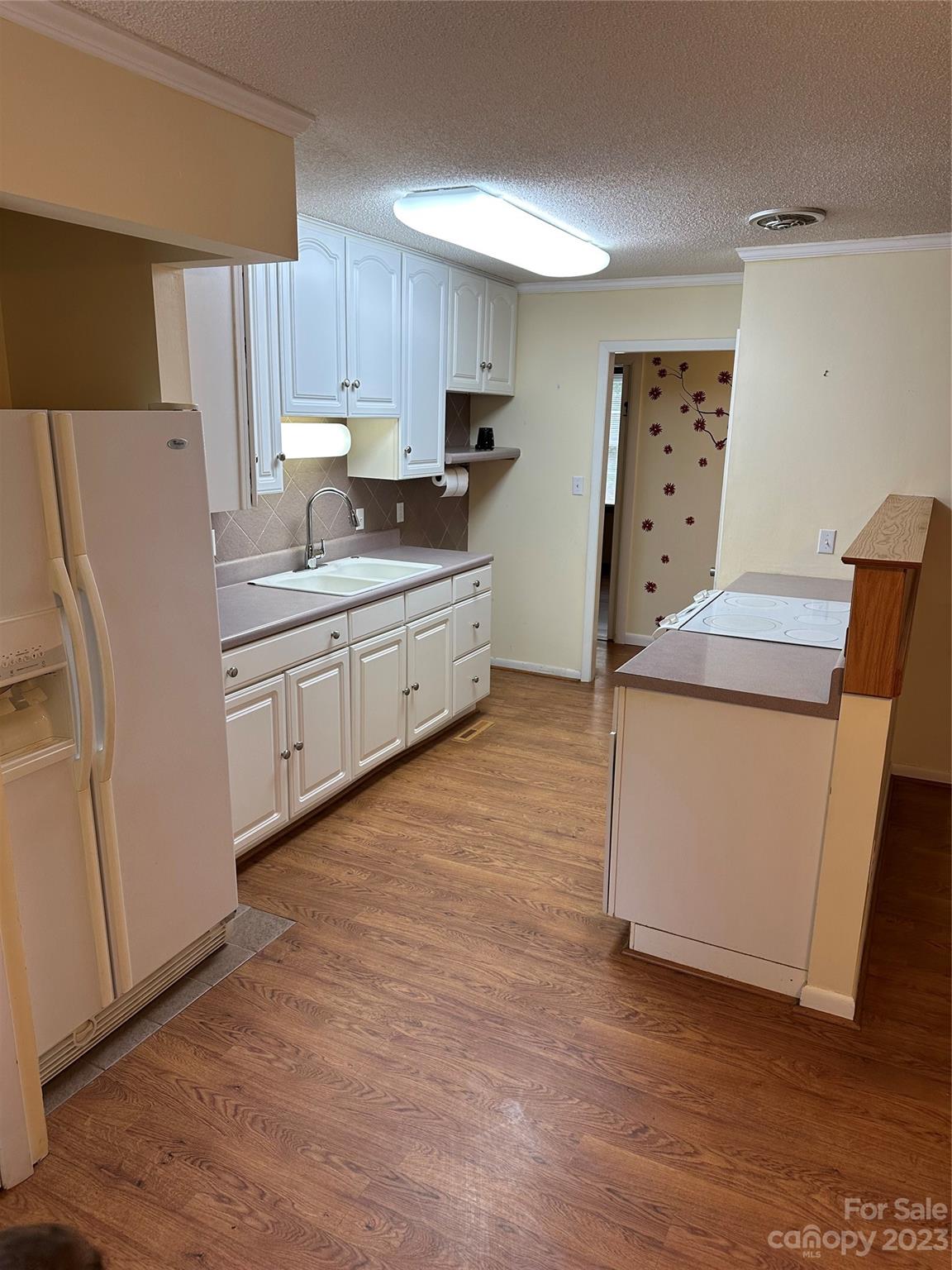 140 Hillside Drive Salisbury, NC 28147 - Photo 12 of 29 a kitchen with granite countertop a refrigerator a sink and wooden floors