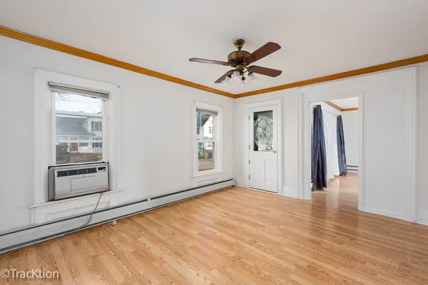 a view of a livingroom with wooden floor and a ceiling fan