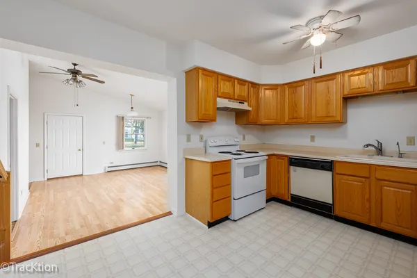 a kitchen with stainless steel appliances granite countertop a sink cabinets and wooden floor