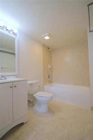 a bathroom with a bathtub shower sink mirror vanity and toilet