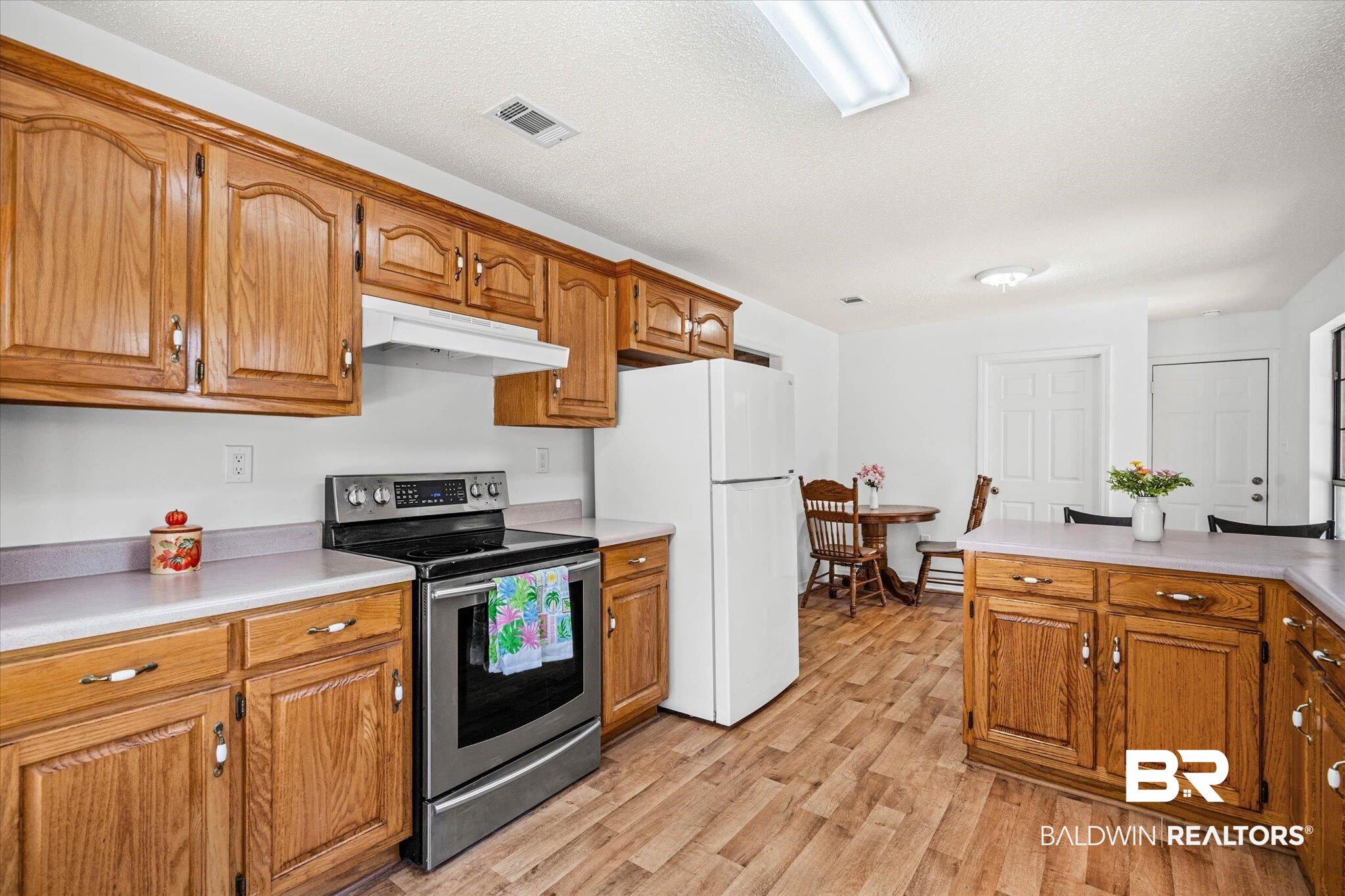 9770 Lakeview Road Bay Minette, AL 36507 - Photo 13 of 44 Kitchen featuring stainless steel electric stove, light countertops, freestanding refrigerator, wood finish cabinets, and light wood-style flooring