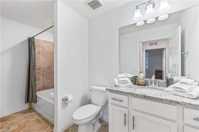 a bathroom with a granite countertop sink a toilet and a mirror