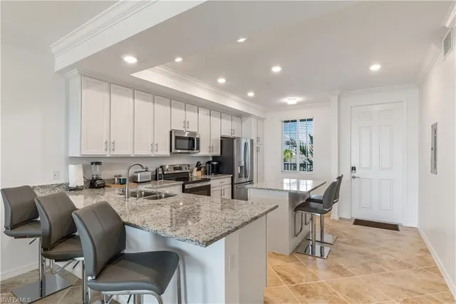 a kitchen with granite countertop sink table and chairs