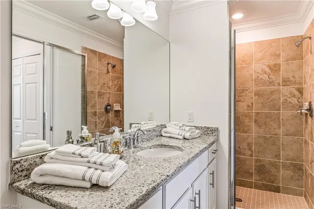 a en suite bathroom with a granite countertop double vanity sink and a mirror