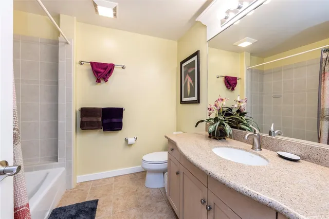 a bathroom with a granite countertop double vanity sink mirror and toilet