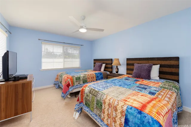 a bedroom with two beds and a flat screen tv